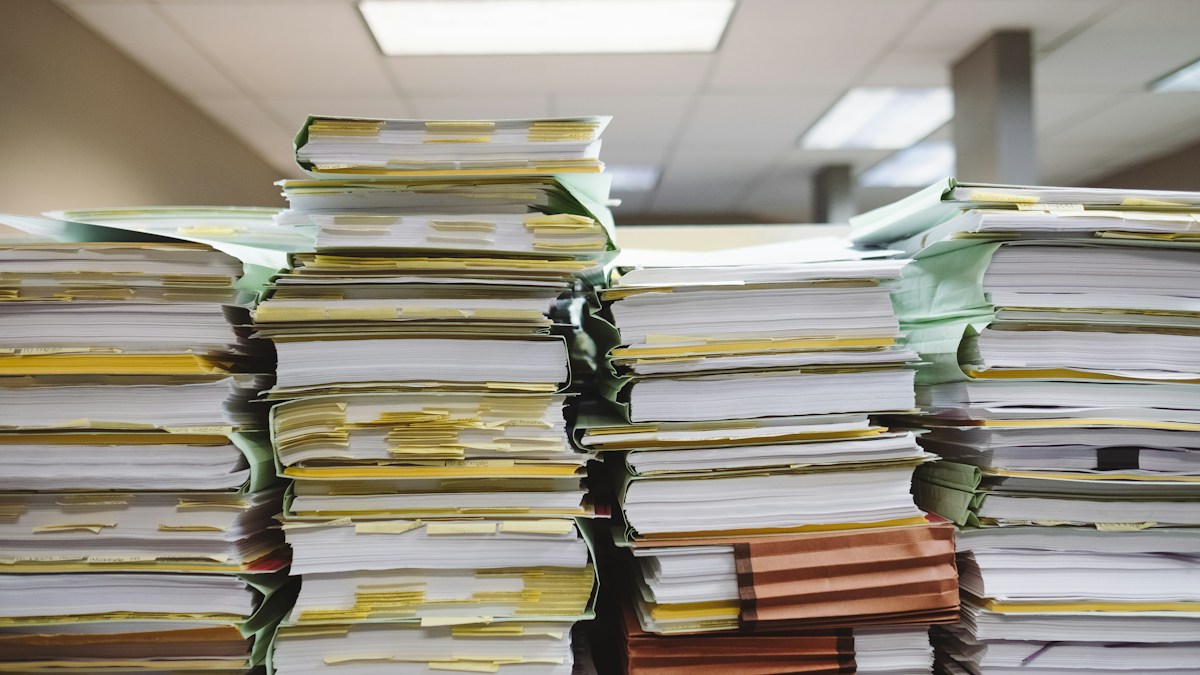 Stacks of folders and office documents, illustrating the paperwork behind a Minecraft Marketplace payout diagnosis